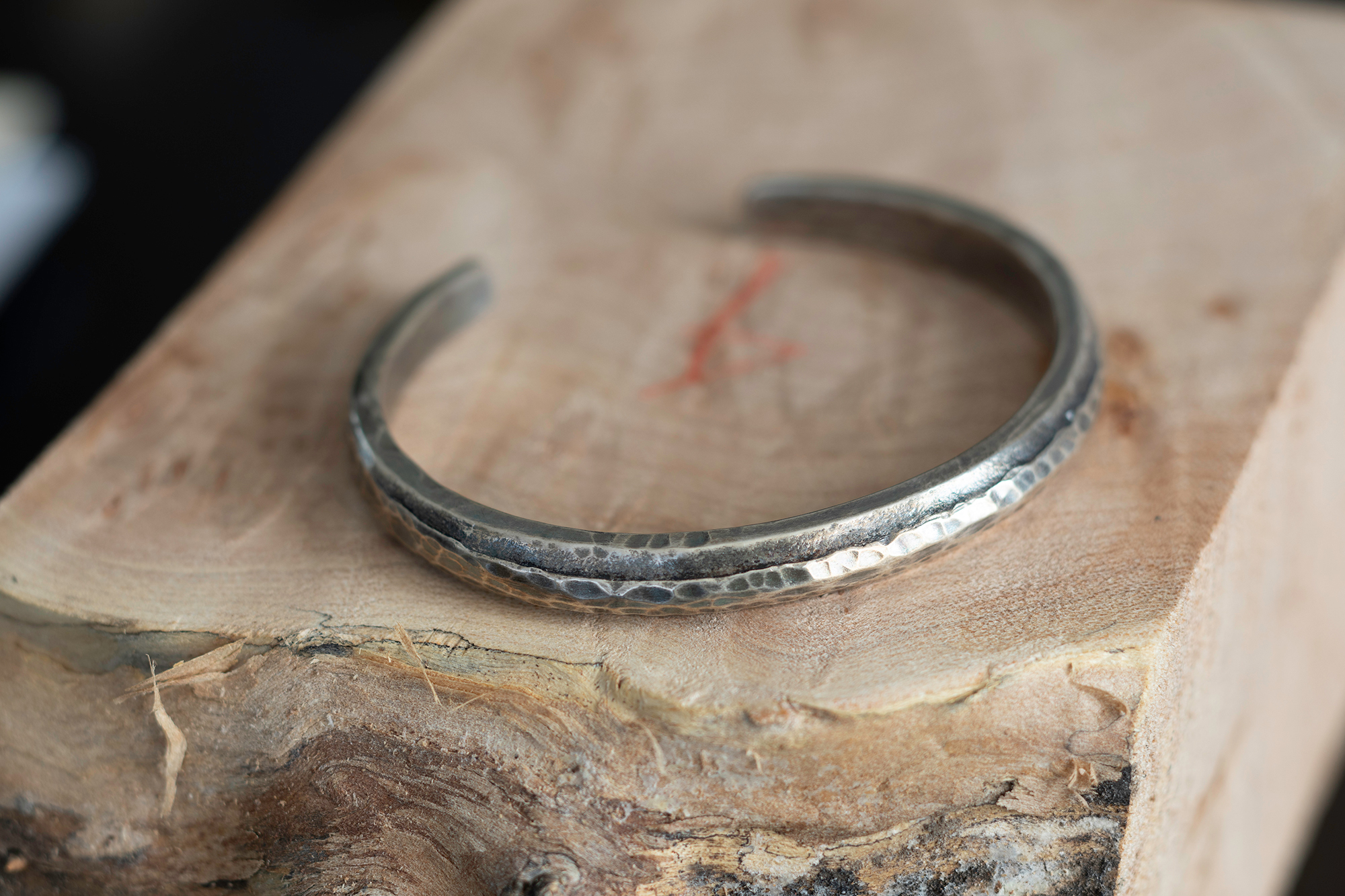 Cuff on natural wood block.