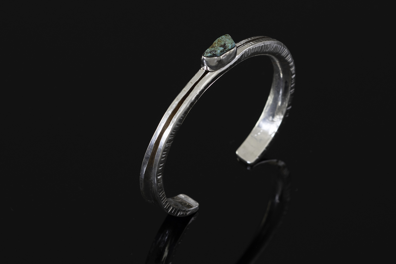 Bracelet on black reflective table.